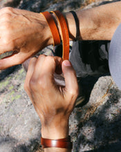 Lataa kuva Galleria-katseluun, Miehen kädessä nahkaiset rannekorut